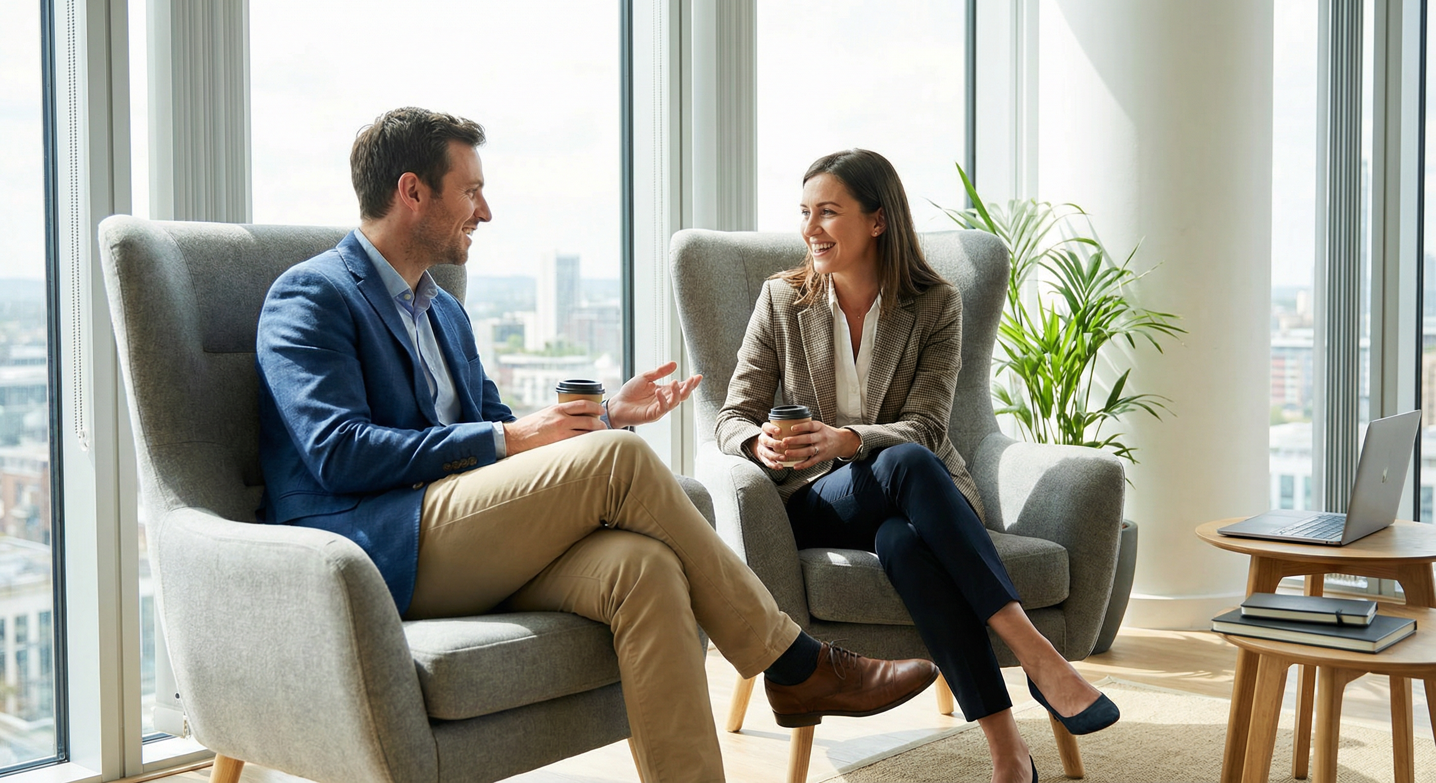Dos personas en conversación en sillones en oficina